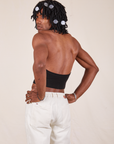 Angled back view of Halter Top in Basic Black and vintage off-white Western Pants worn by Jerrod