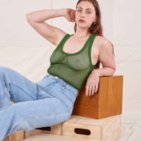 Allison is sitting on a wooden crate wearing Mesh Tank Top in Lawn Green