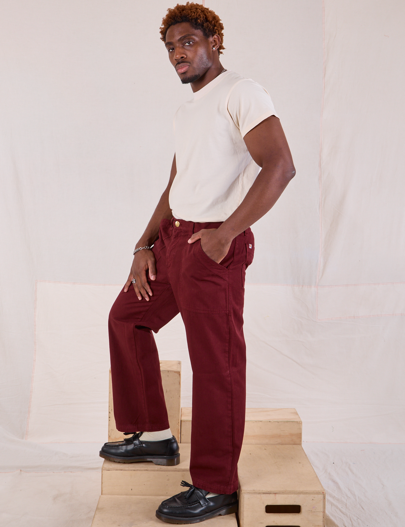 Side view of Mid-Rise Work Pants in Red Wine and Organic Vintage Tee in vintage tee off-white on Issac