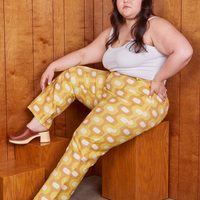 Ashley is sitting on a wooden crate wearing Western Pants in Yellow Jacquard