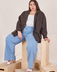 Marielena is wearing Oversize Overshirt in Espresso Brown, vintage off-white Cropped Tank Top, and light wash Sailor Jeans