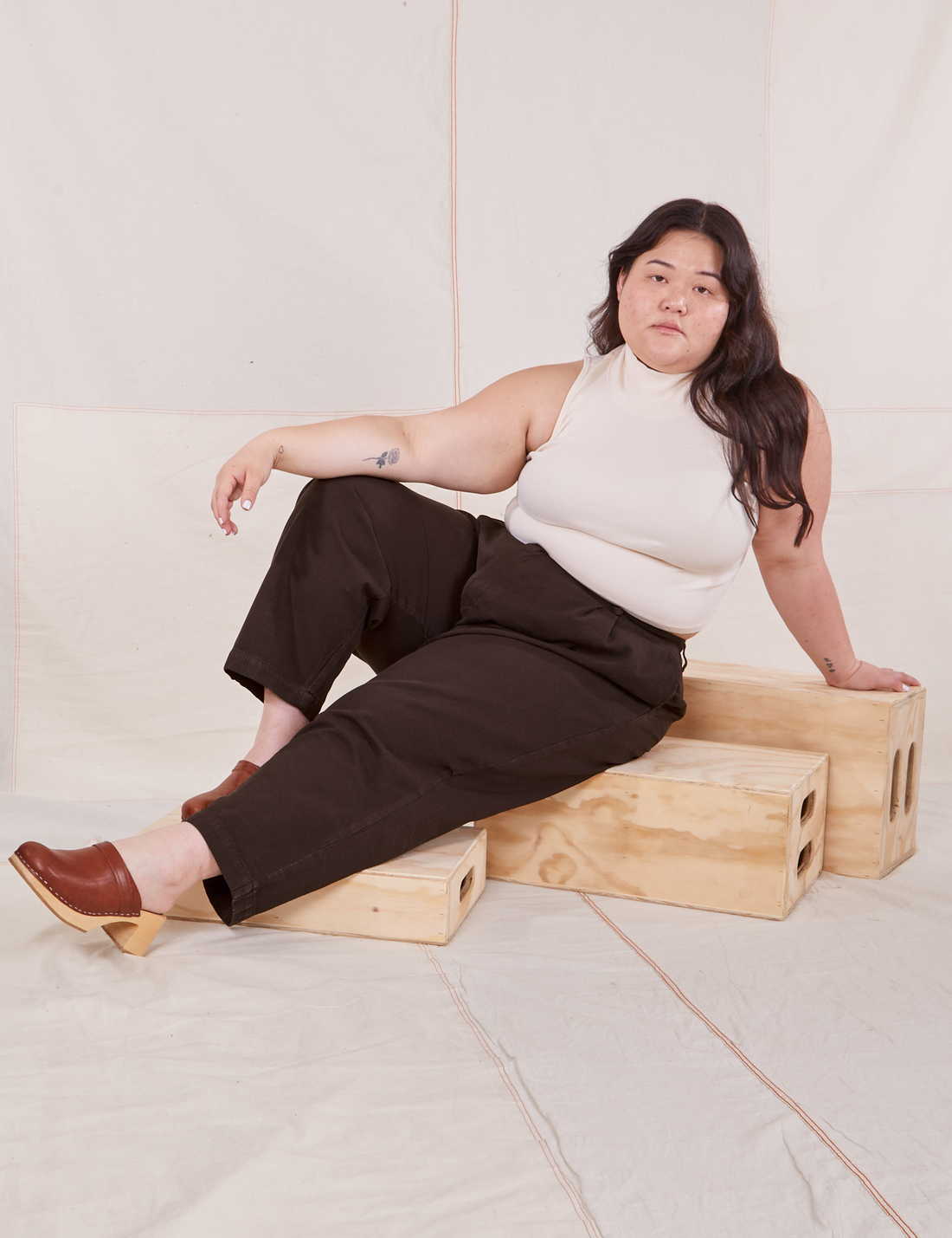 Ashley is wearing Heritage Trousers in Espresso Brown and vintage off-white Sleeveless Turtleneck
