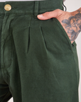 Heritage Trousers in Swamp Green front pocket close up. Jesse has their hand in the pocket.