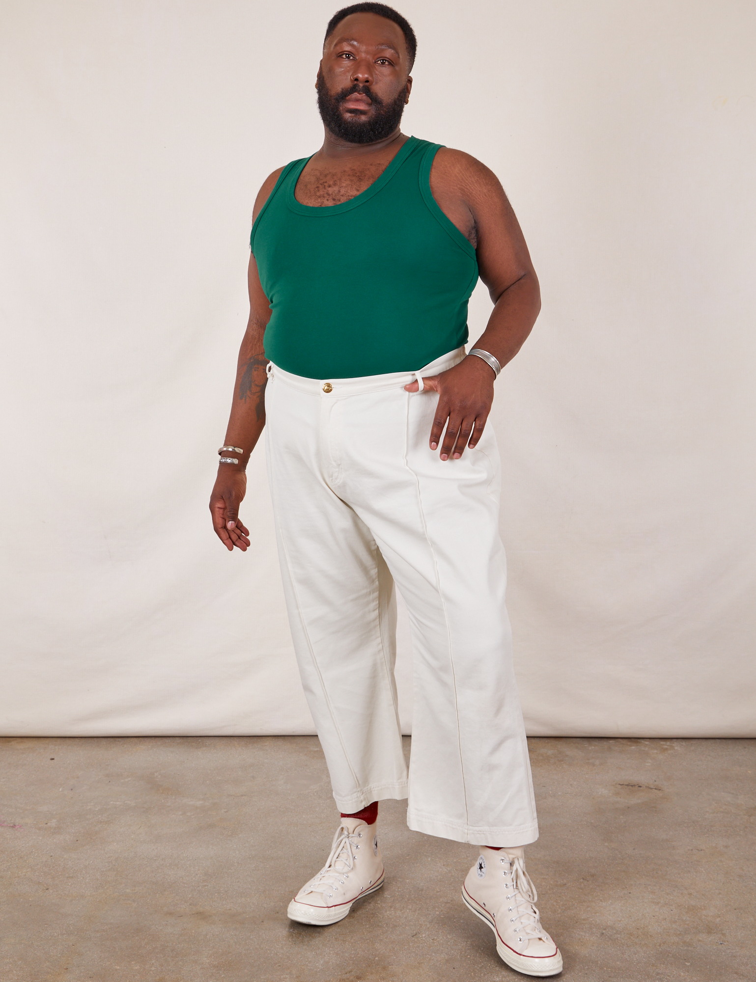 Elijah is wearing Tank Top in Hunter Green and vintage tee off-white Western Pants