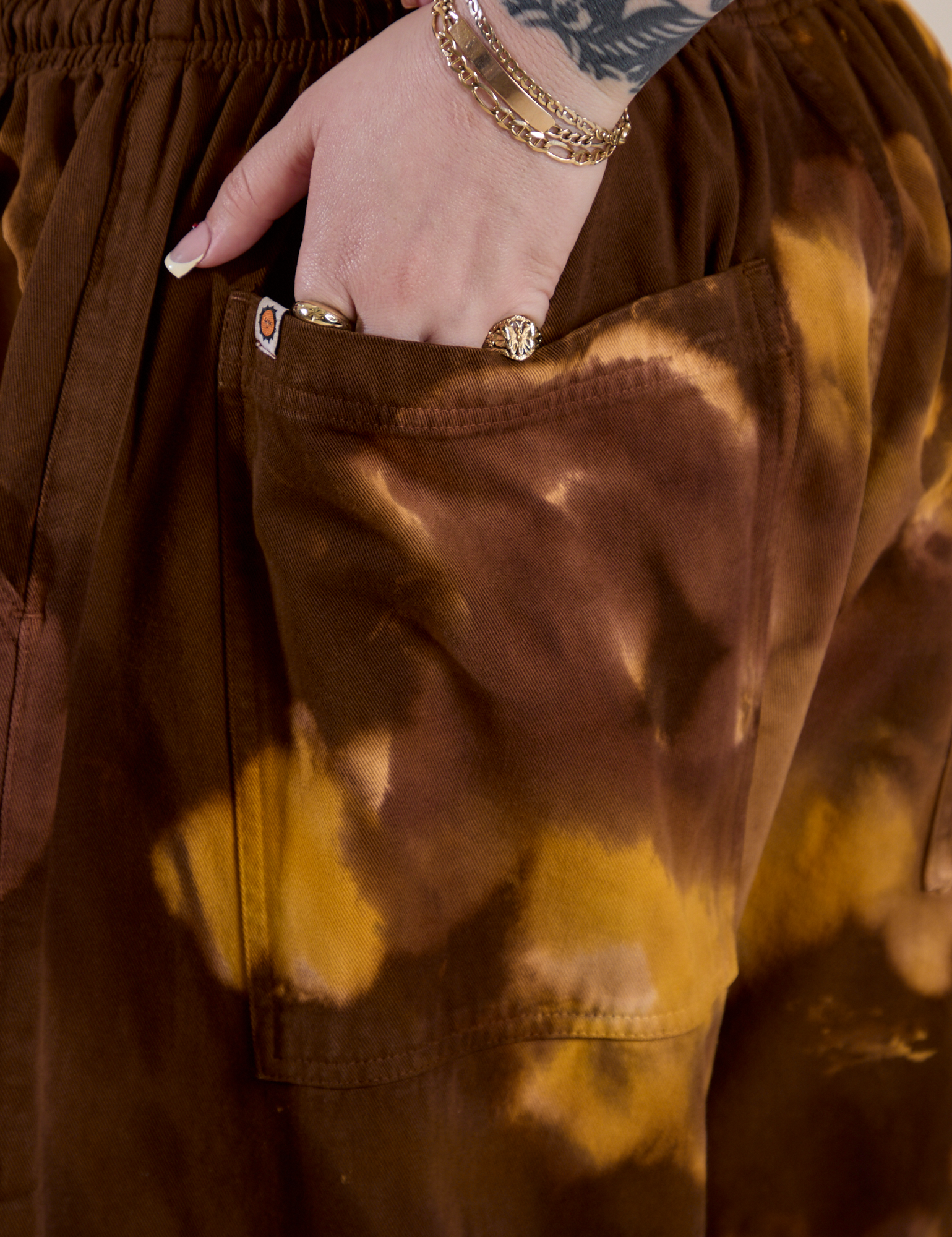 Close up of Sydney's hand in the back pocket of Magic Waters Drop Pocket Pants in Honey Brown
