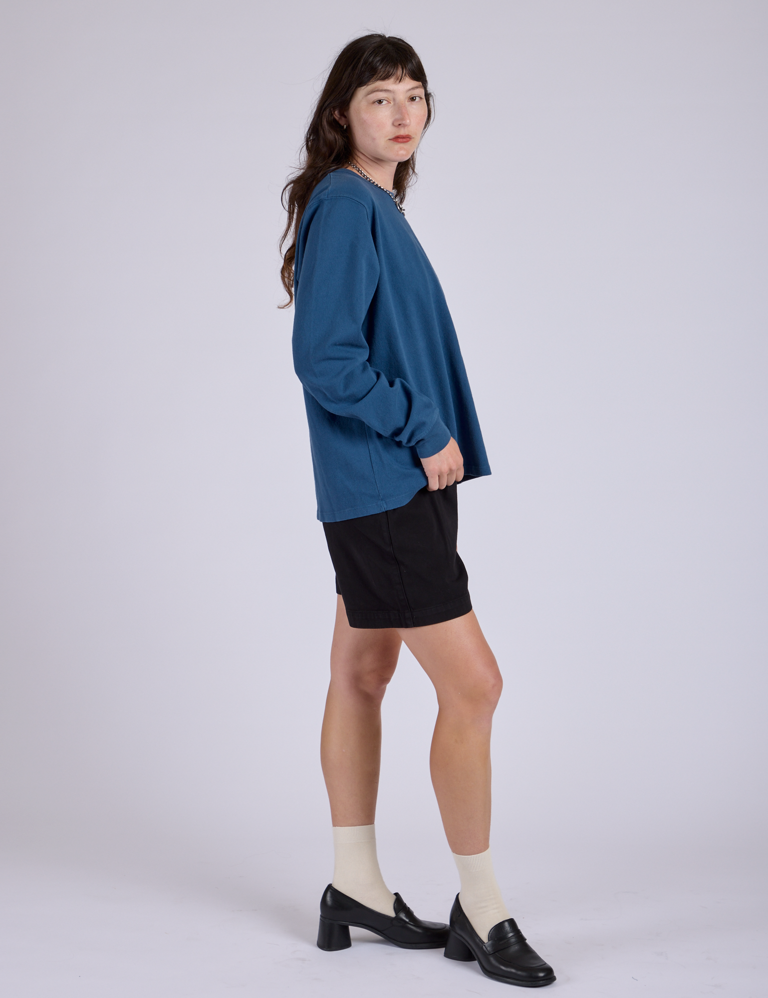 Side view of Pleated Trouser Shorts in Basic Black and Long Sleeve Burly Tee in French Blue