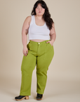 Ashley is 5’7” and wearing 1XL Work Pants in Gross Green paired with vintage tee white Cropped tank