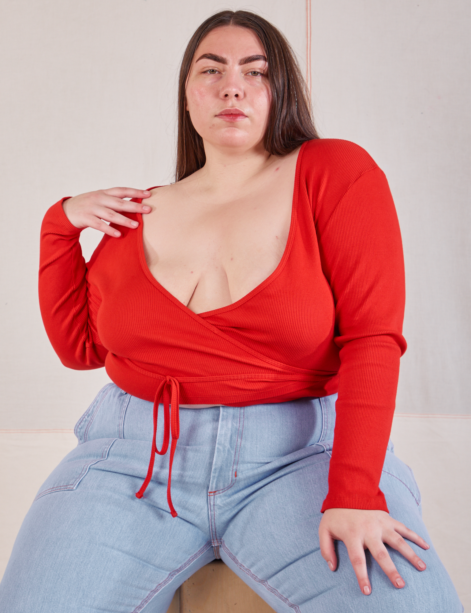 Marielena is wearing Wrap Top in Mustang Red and light wash Carpenter Jeans