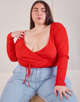 Marielena is wearing Wrap Top in Mustang Red and light wash Carpenter Jeans