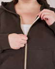 Cropped Zip Hoodie in Espresso Brown front close up. Marielena is pulling on the zipper tab.