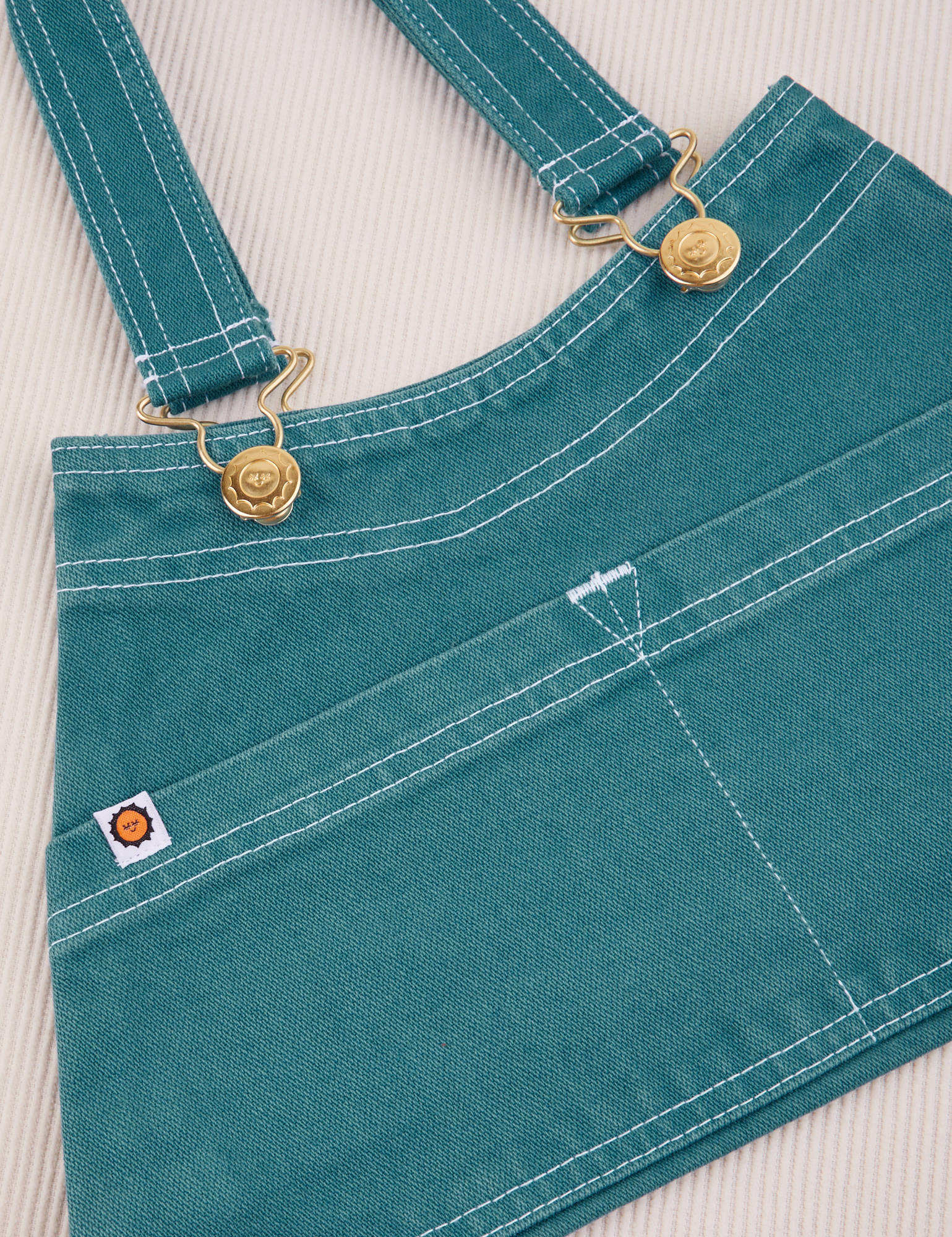 Overall Handbag in Marine Blue. White contrast stitching. Brass sun baby buttons and hardware