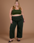Juliet is 5’7” and wearing 1XL Action Pants in Swamp Green paired with evergreen Mini Tank