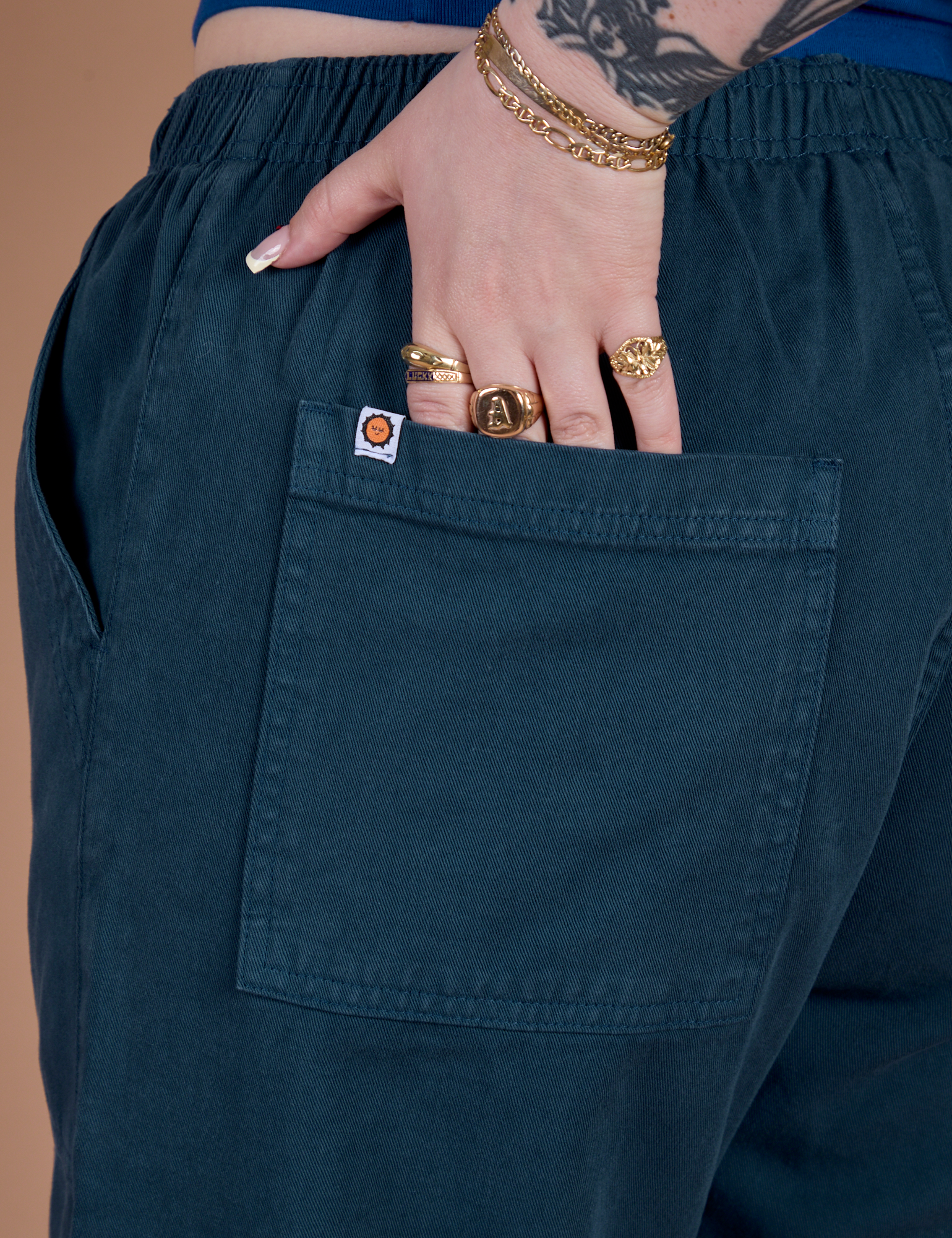 Close up of Sydney's hand in the back pocket of Action Pants in Lagoon