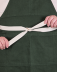 Full Denim Apron in Swamp Green with strap tied around waist in a bow