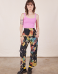 Hana is 5'3" and wearing XXS Petite Rainbow Magic Waters Work Pants paired with bubblegum pink Cropped Cami