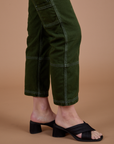 Carpenter Jeans in Evergreen pant leg side view on Alex