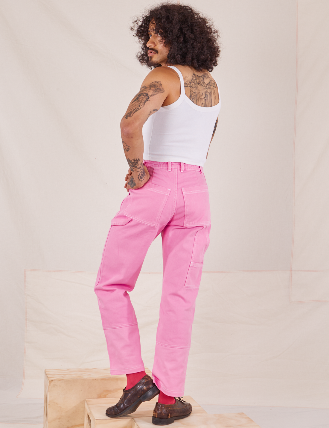 Back view of Carpenter Jeans in Bubblegum Pink worn by Jesse