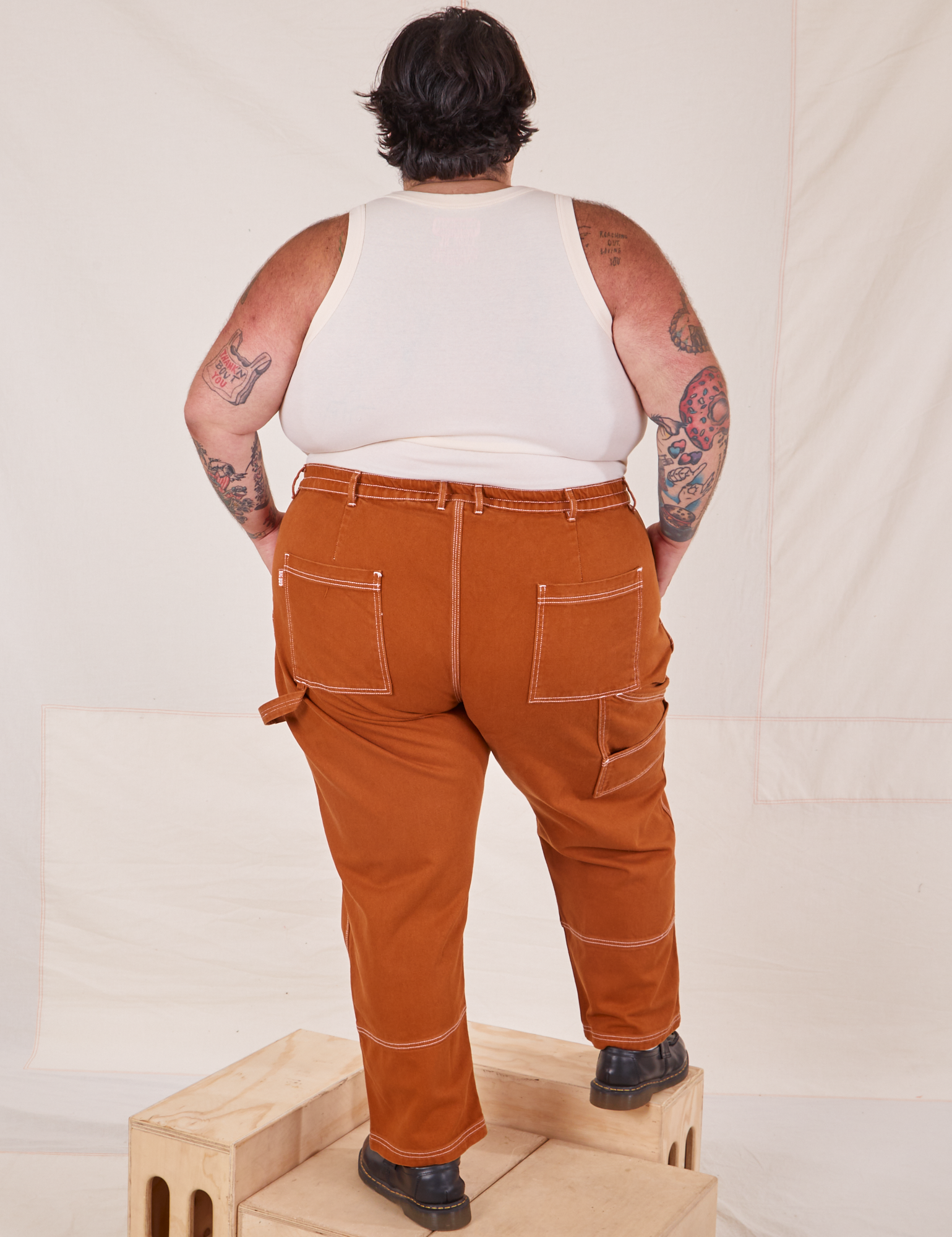 Back view of Carpenter Jeans in Burnt Terracotta and vintage off-white Cropped Tank Top on Sam