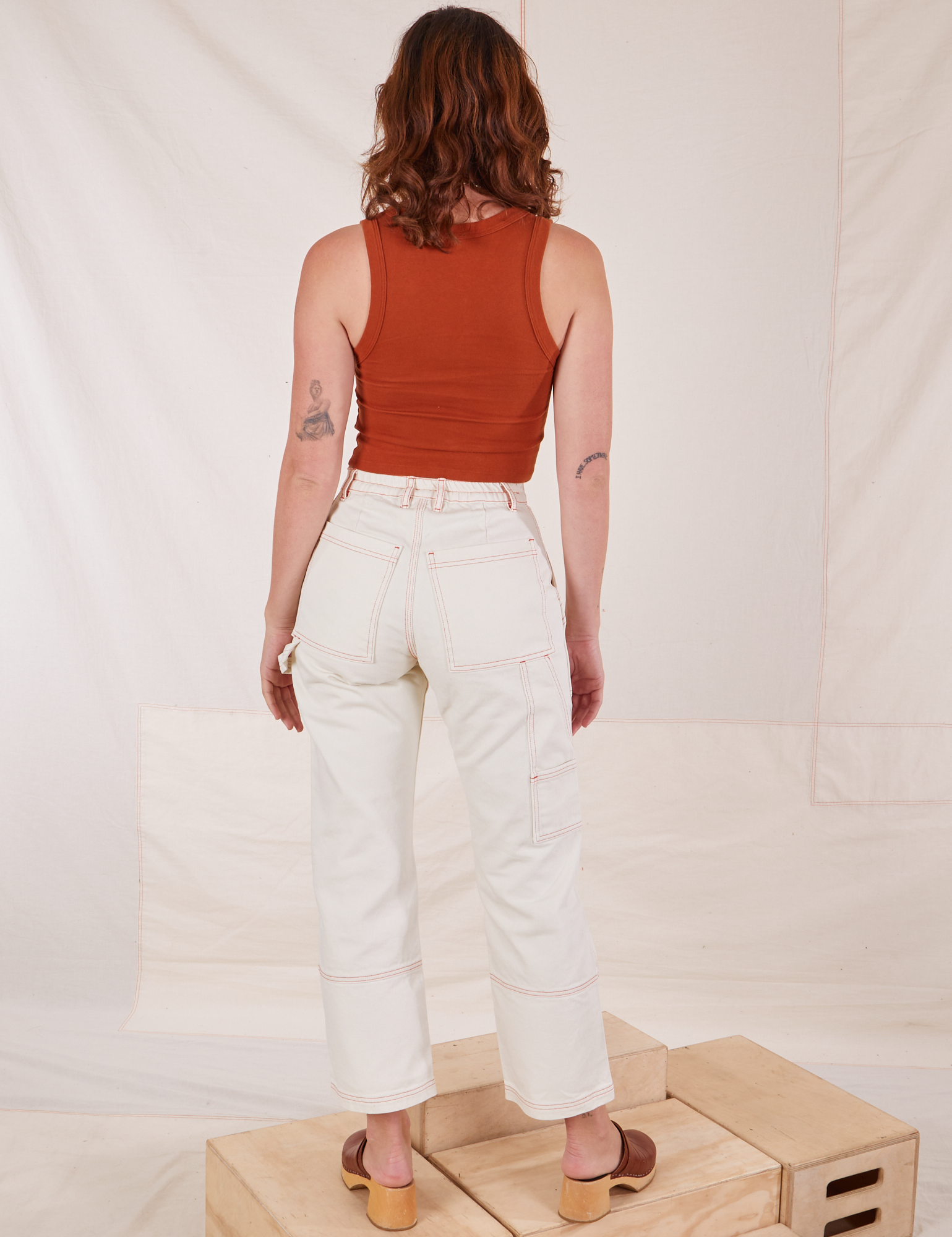 Back view of Carpenter Jeans in Vintage Off-White and burnt terracotta Cropped Tank Top on Alex