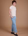 Angled front view of Carpenter Jeans in Light Wash and Organic Vintage Tee in Vintage Tee Off-White on Quinn