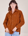 Alex is wearing a buttoned up Corduroy Overshirt in Burnt Terracotta