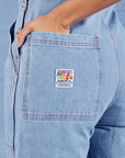 Indigo Denim Original Overalls in Light Wash back pocket close up. Tiara has her hand in the pocket