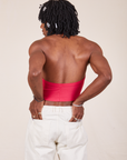 Back view of Halter Top in Hot Pink worn by Jerrod. They are also wearing vintage off-white Western Pants with both hands in the back pockets.