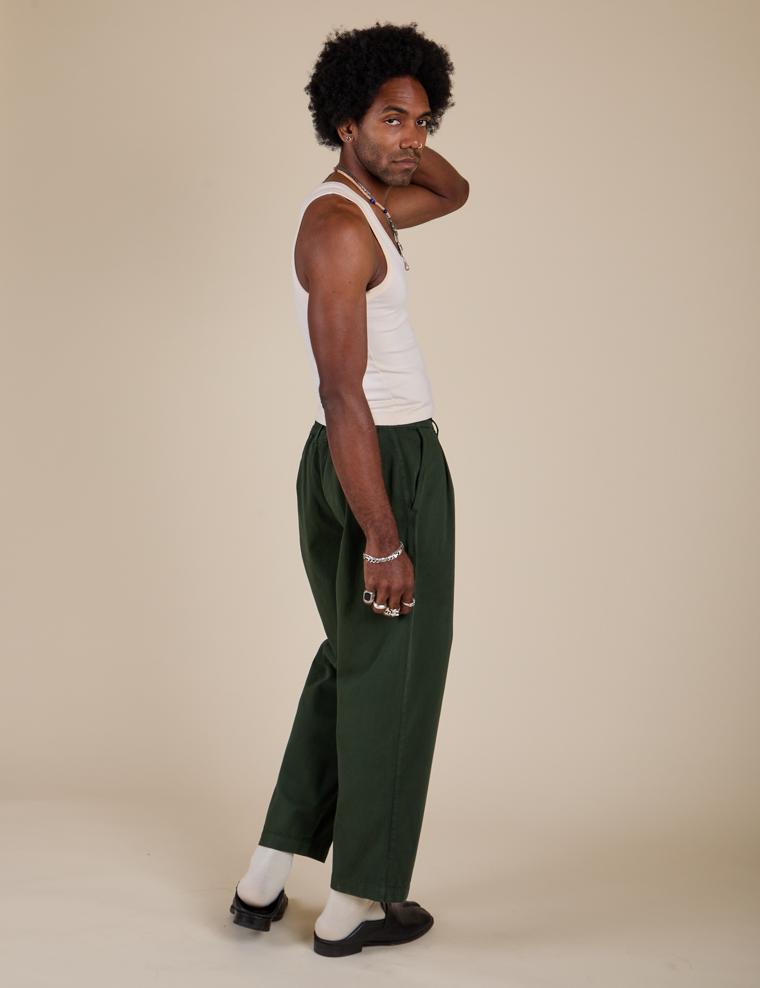 Side view of Heavyweight Trousers in Swamp Green  and Tank Top in Vintage Tee Off-White on Jerrod