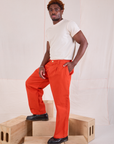 Angled front view of Mid-Rise Pleated Trousers in Chili Red and Organic Vintage Tee in vintage tee off-white