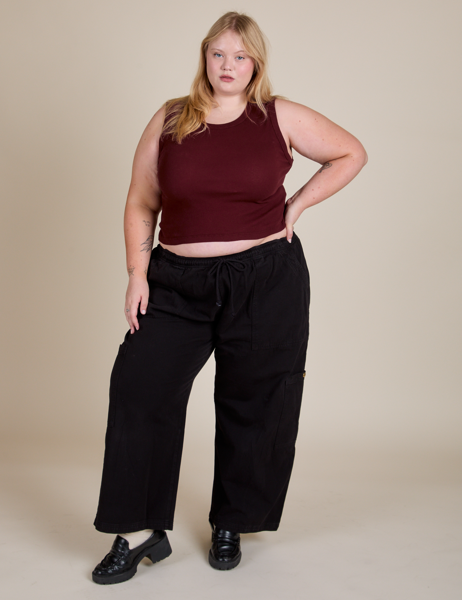 Juliet is wearing Muscle Tee in Red Wine and black Drop Pocket Cargo Pants