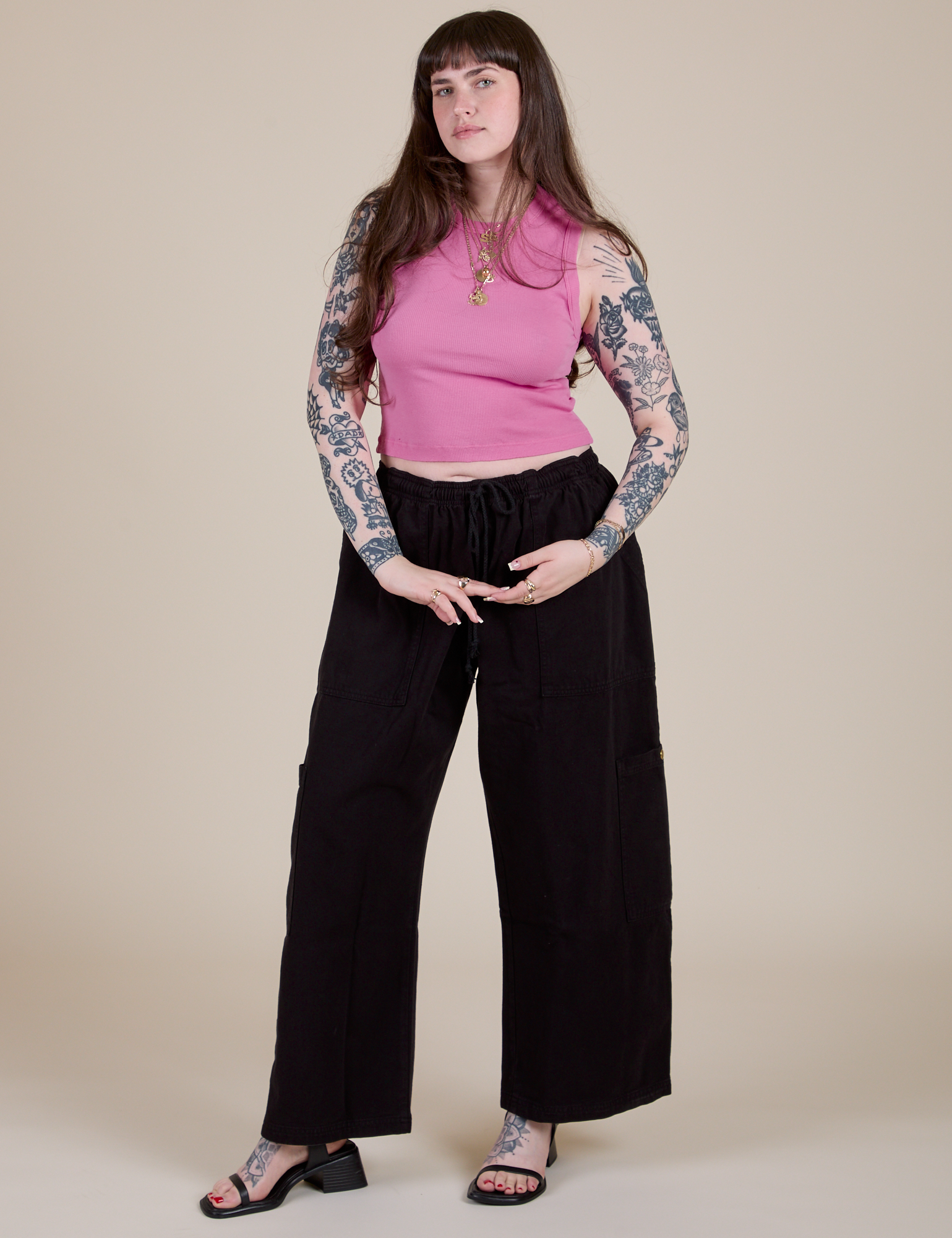Sydney is wearing Muscle Tee in Bubblegum Pink paired with black Drop Pocket Cargo Pants