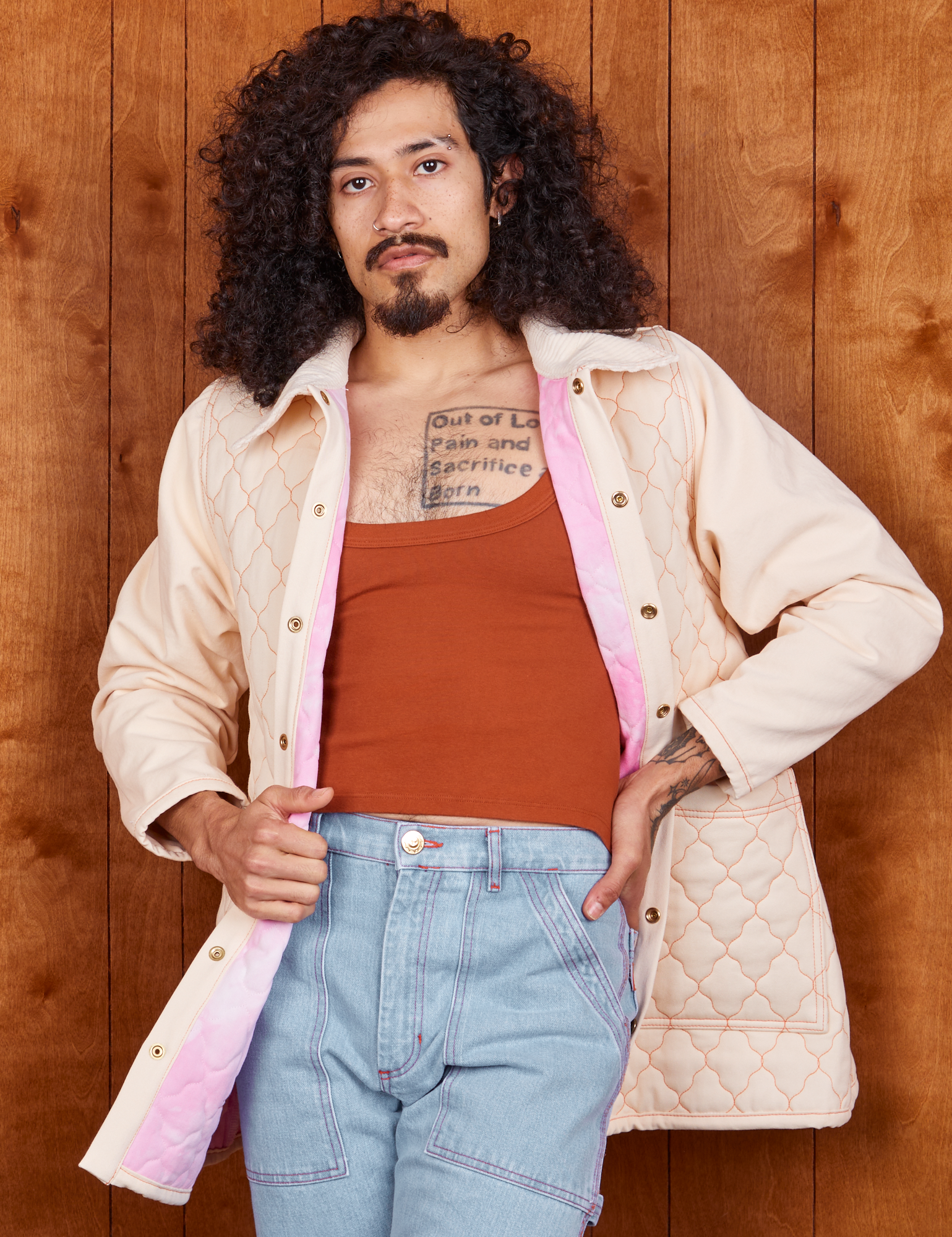 Jesse is wearing Quilted Overcoat in Vintage Off-White, burnt terracotta Cropped Tank Top and light wash Carpenter Jeans