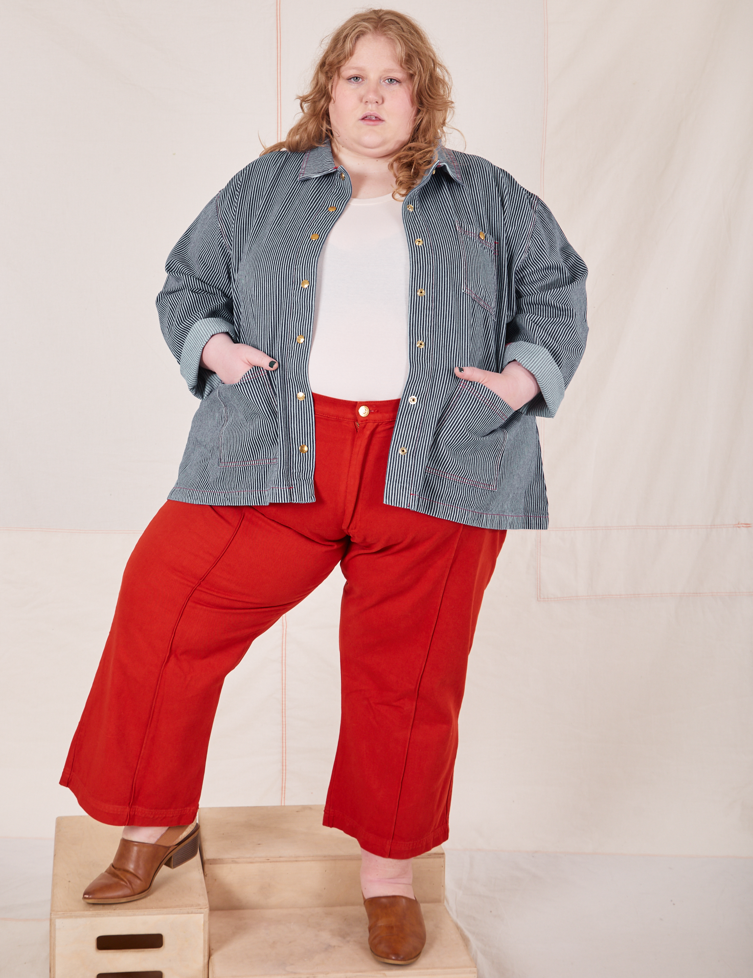 Catie is 5&#39;11&quot; and wearing 4XLRailroad Stripe Denim Work Jacket paired with paprika Western Pants