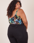 Angled back view of Cropped Cami in Rainbow Magic Waters and black Western Pants worn by Morgan