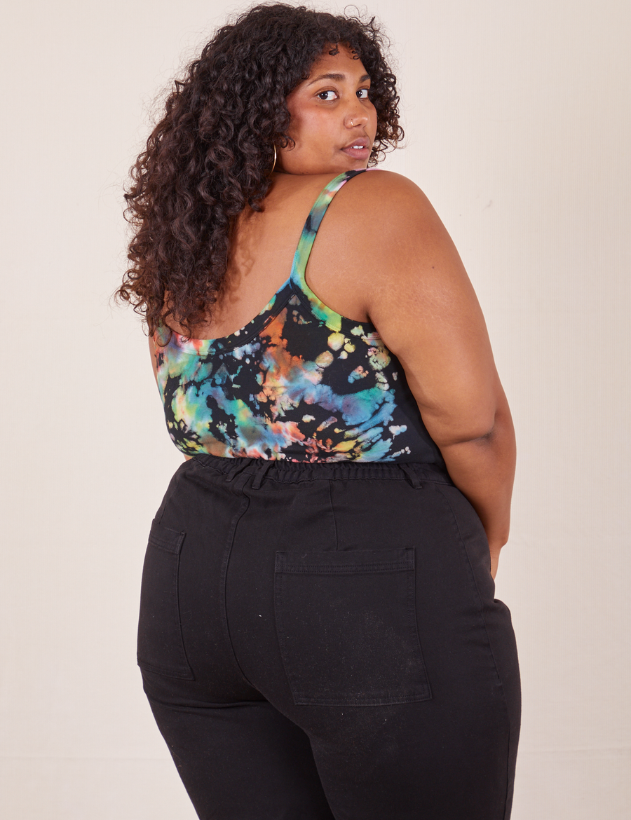 Angled back view of Cropped Cami in Rainbow Magic Waters and black Western Pants worn by Morgan