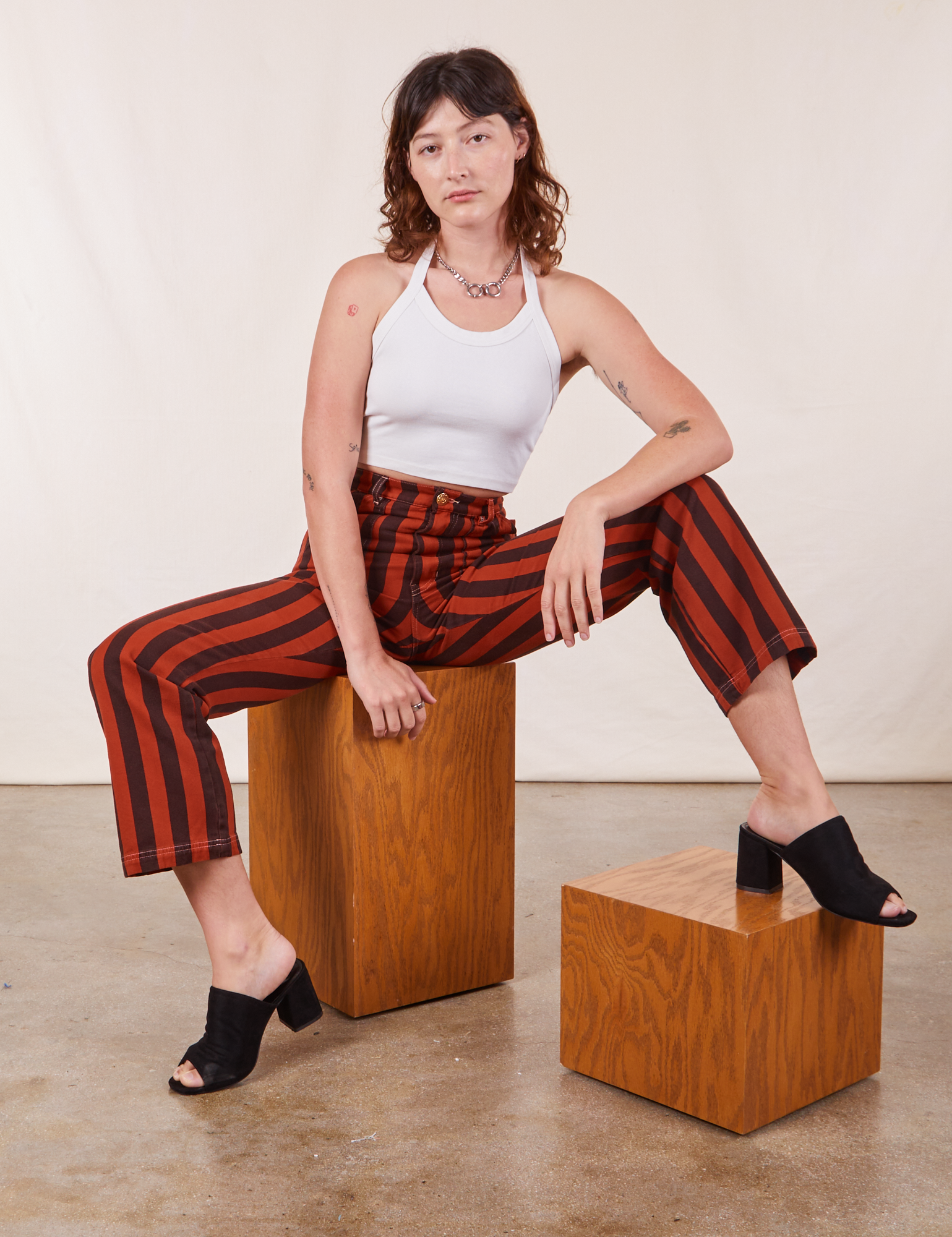 Alex is wearing Black Striped Work Pants in Paprika and vintage off-white Halter Top