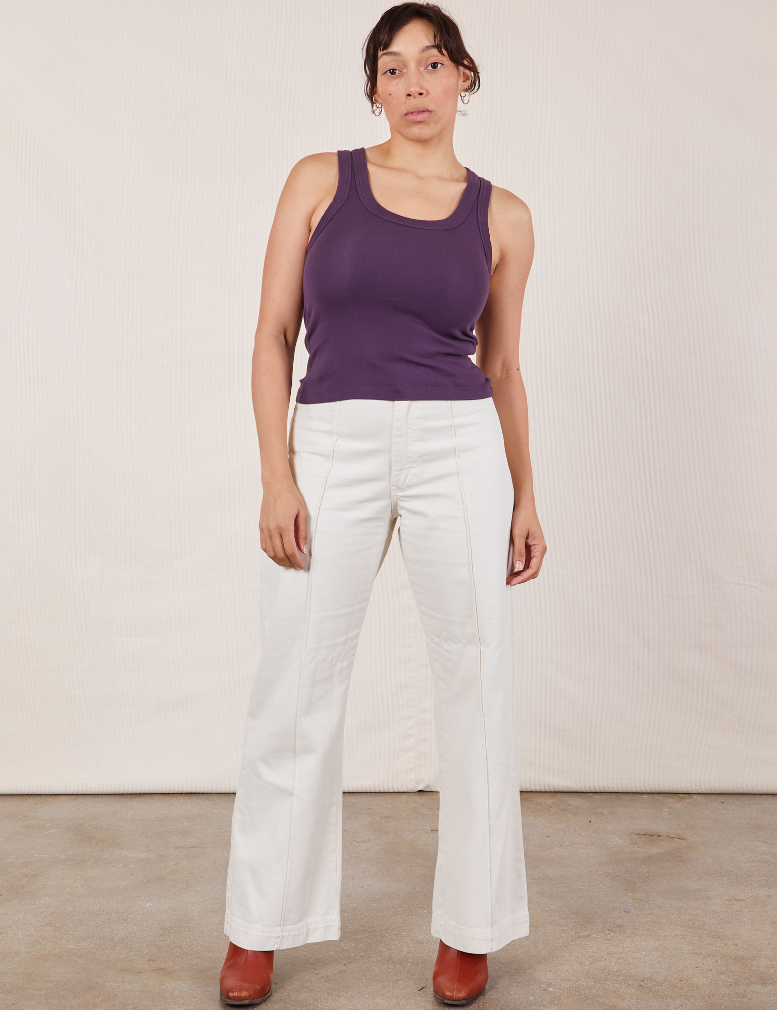 Tiara is 5’4” and wearing XS Tank Top in Nebula Purple paired with vintage tee off-white Western Pants
