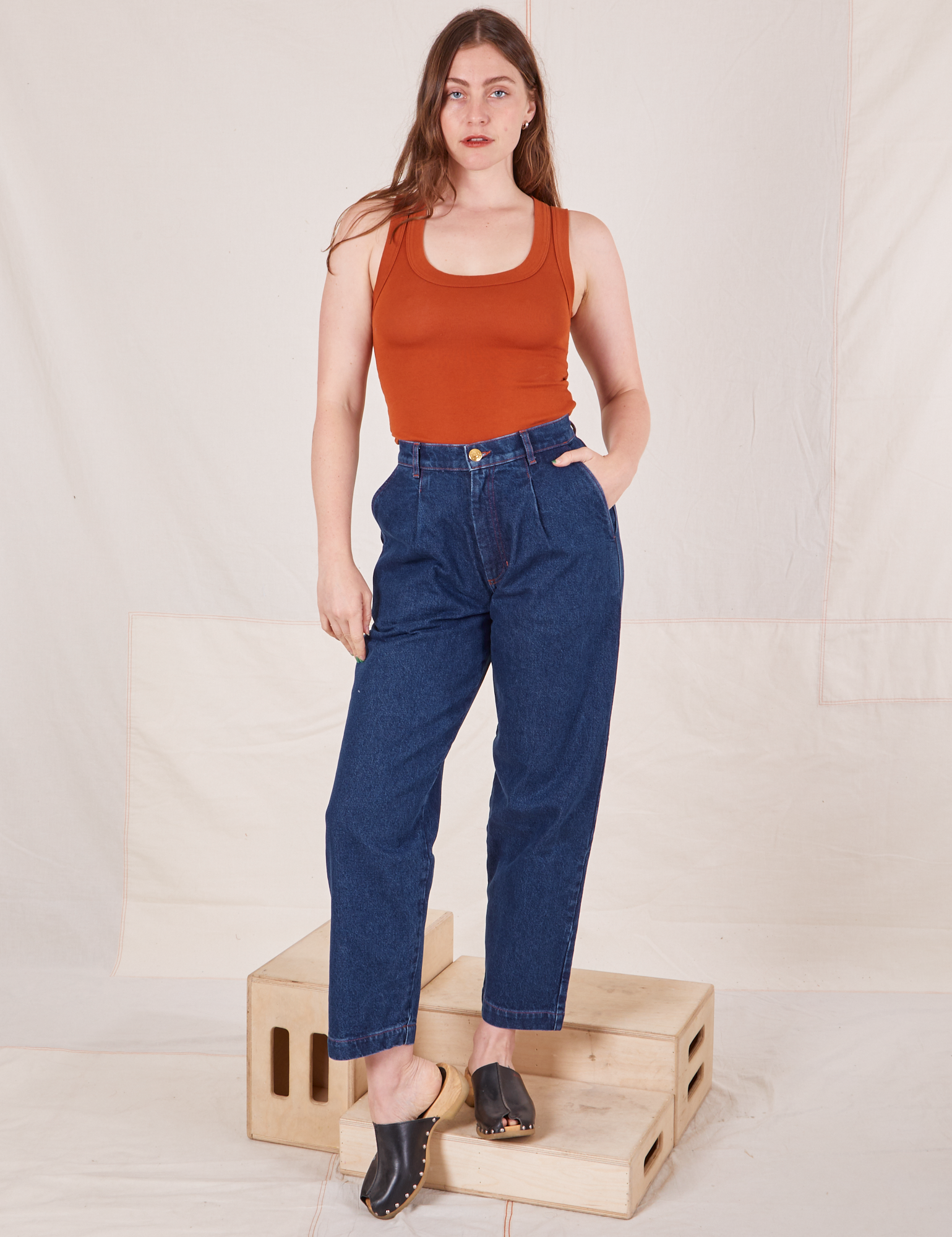 Allison is 5&#39;10&quot; and wearing XS Denim Trouser Jeans in Dark Wash paired with burnt orange Tank Top