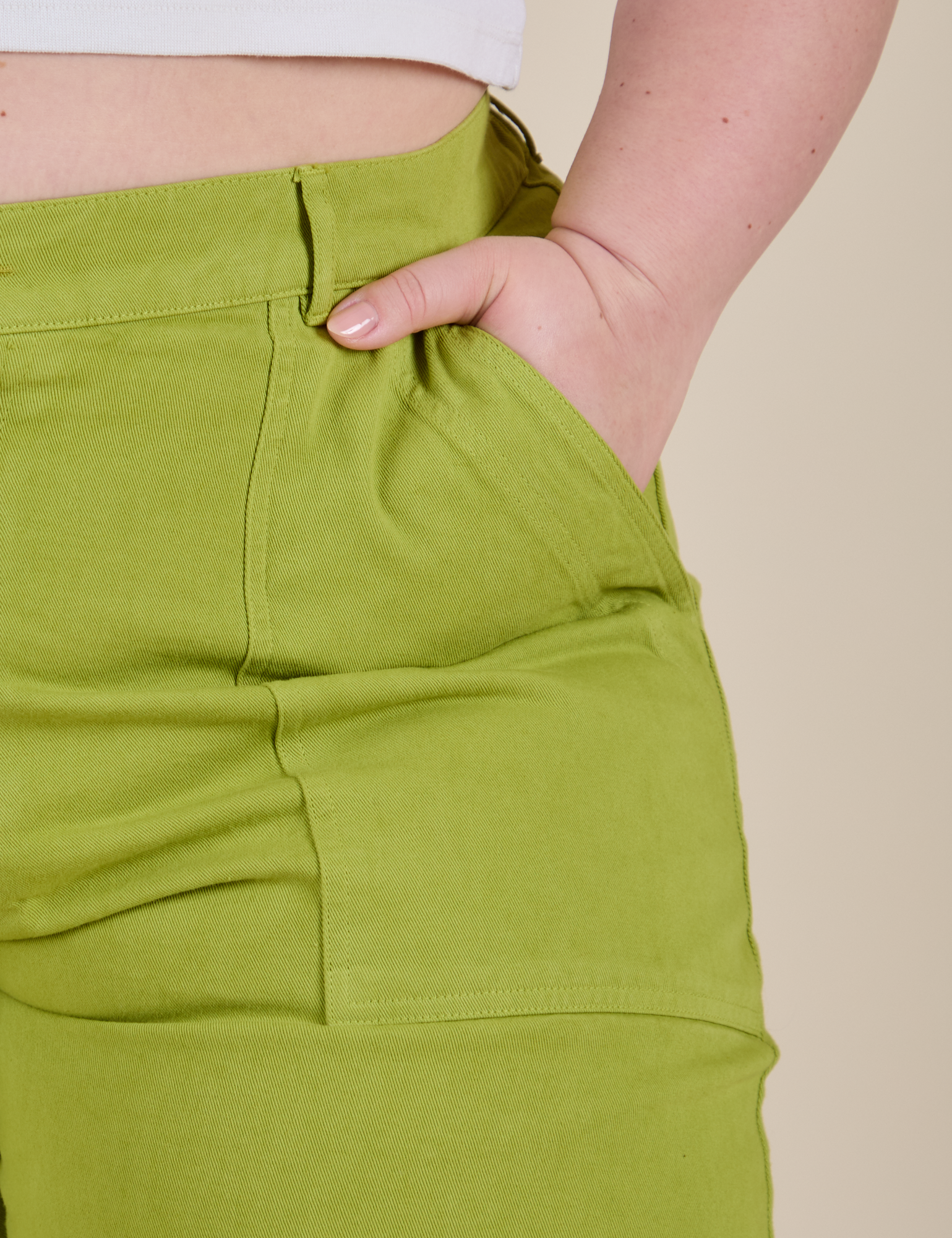 Close up of Ashley's hand in the front pocket of Work Pants in Gross Green