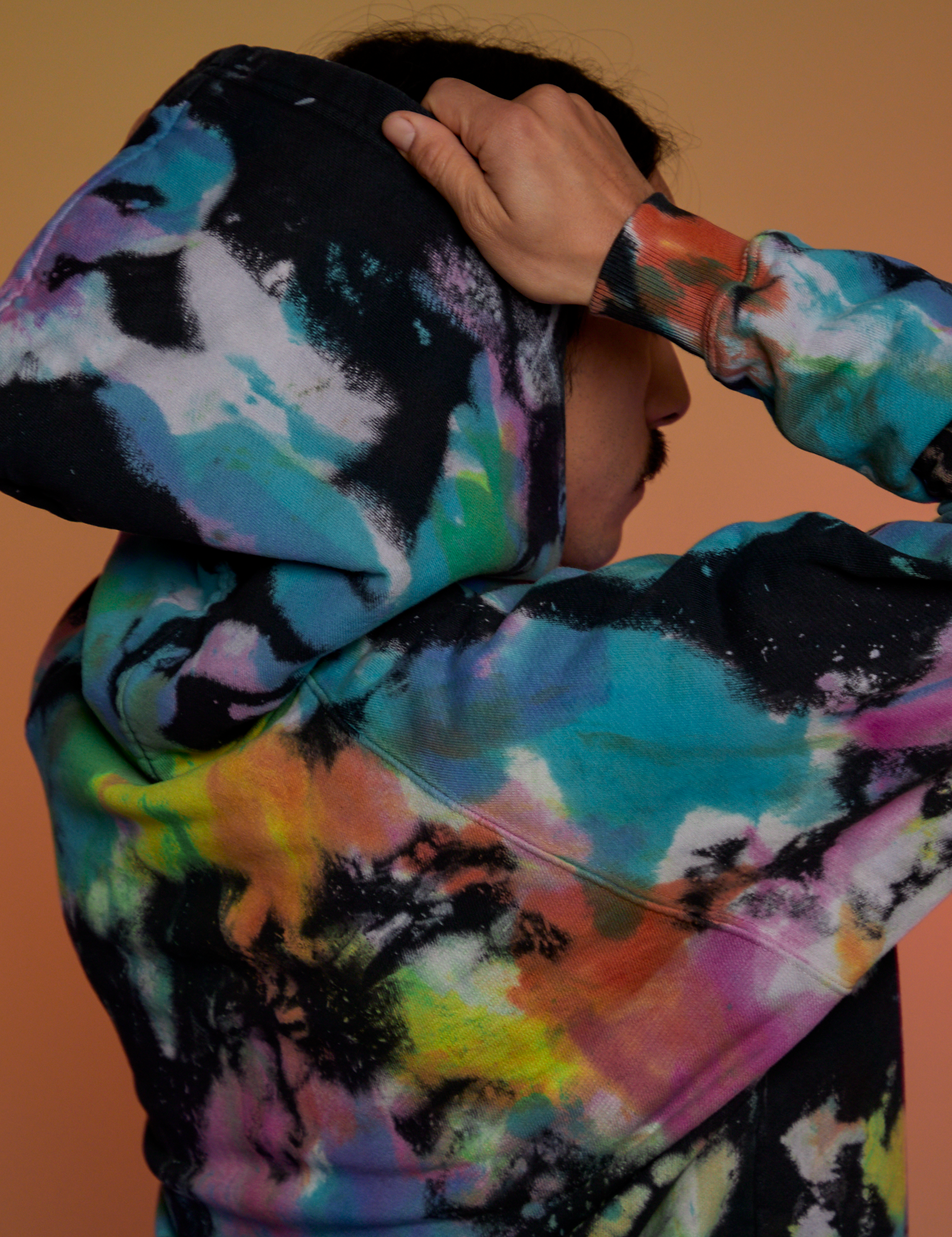 Angled back view close up of Oversized Hoodie in Rainbow Magic Waters on Anthony