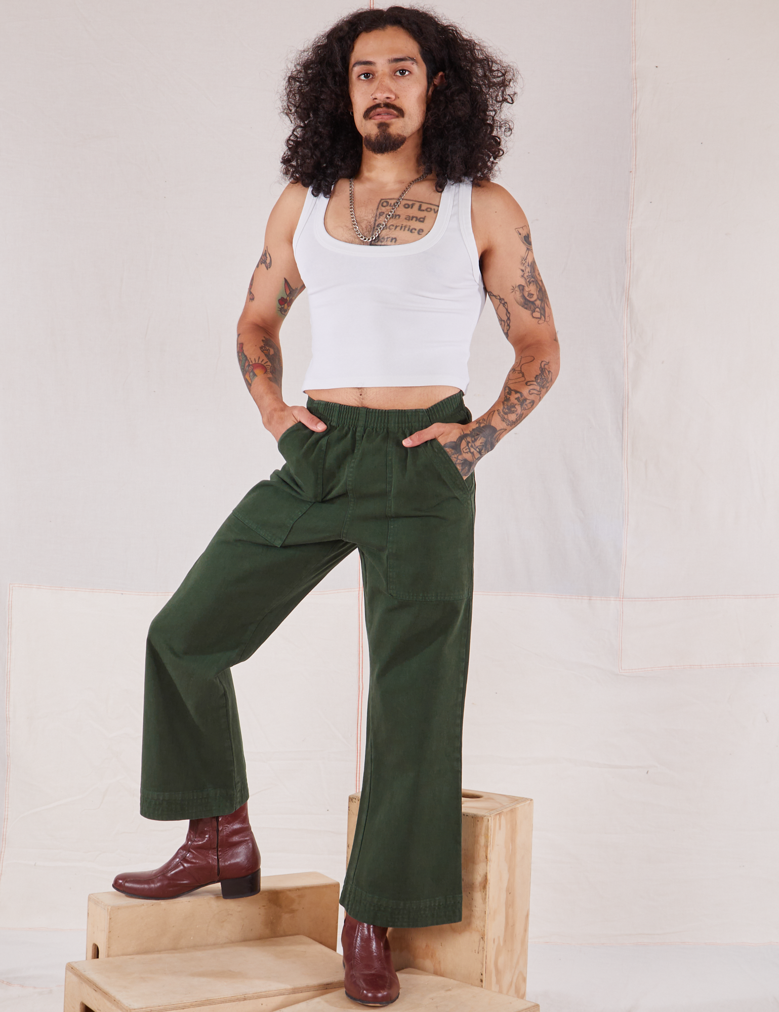 Jesse is 5&#39;8&quot; and wearing XXS Action Pants in Swamp Green paired with a Cropped Tank in vintage tee off-white