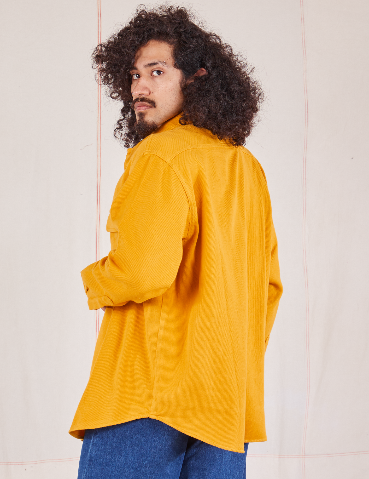 Angled back view of Flannel Overshirt in Mustard Yellow on Jesse