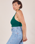 Side view of Halter Top in Hunter Green and light wash Sailor Jeans worn by Tiara