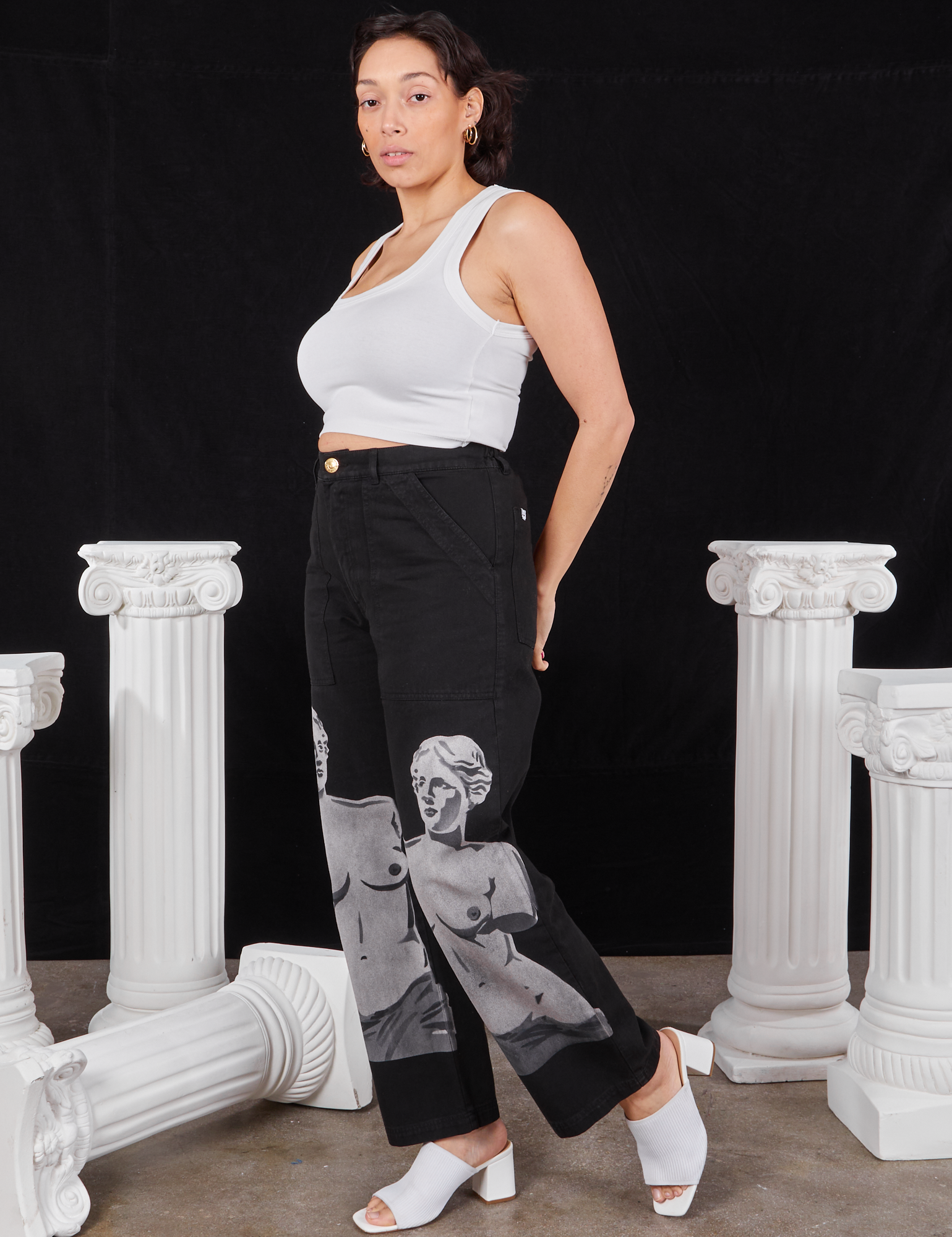 Angled front view of Black Venus Work Pants and vintage off-white Cropped Tank Top