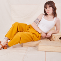 Hana is wearing Organic Trousers in Mustard Yellow and vintage off-white Cami