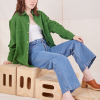 Hana is wearing Oversize Overshirt in Lawn Green, vintage off-white Cropped Tank Top and light wash Sailor Jeans
