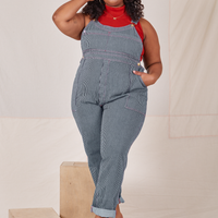 Morgan is 5'5" and wearing 1XL Railroad Stripe Denim Original Overalls paired with a paprika Sleeveless Turtleneck