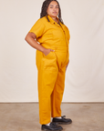 Side view of Short Sleeve Jumpsuit in Mustard Yellow worn by Alicia