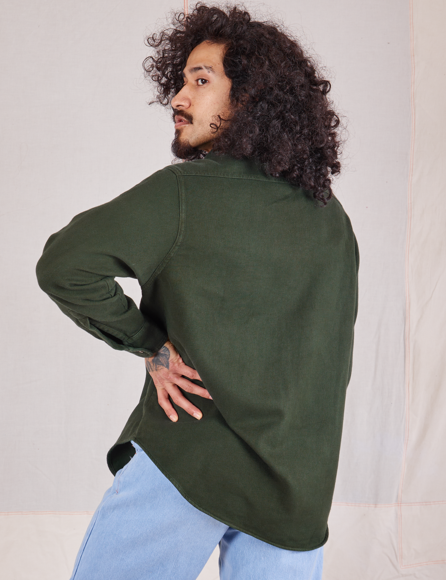 Angled back view of Flannel Overshirt in Swamp Green on Jesse