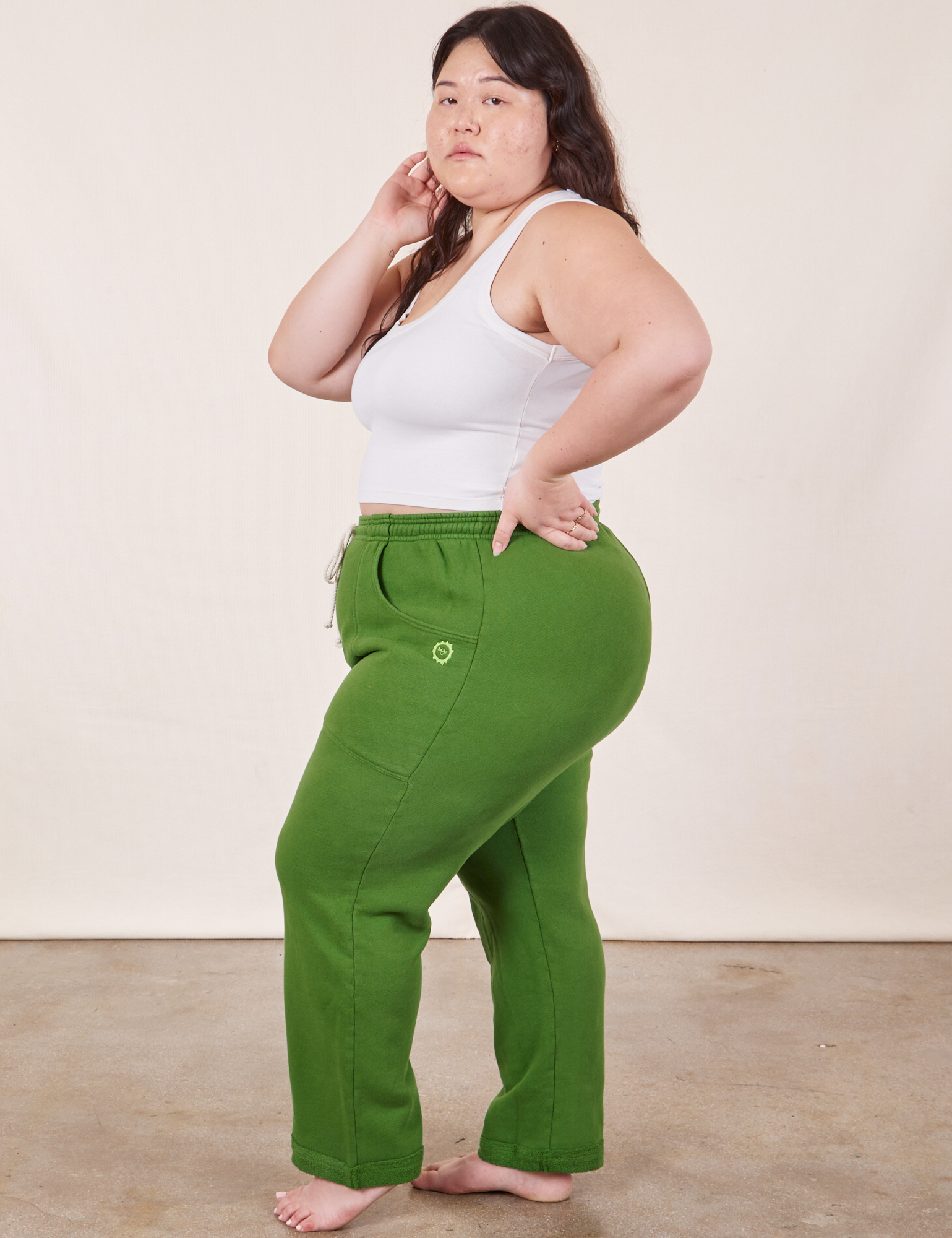 Side view of Cropped Rolled Cuff Sweatpants in Lawn Green and vintage off-white Cropped Tank Top on Ashley